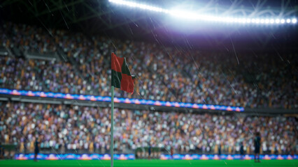Computer graphics corner post on soccer pitch with fans in stadium stands on rainy night, 3D illustration close up of waving red and black corner flag on football field getting wet by rain. © DC Studio