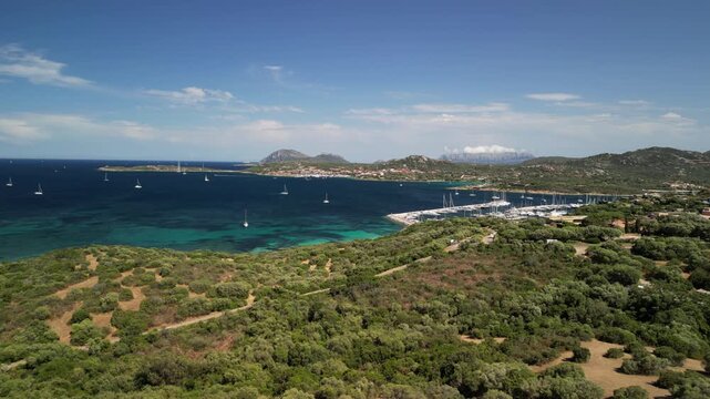 Costa Smeralda - Sardynia - Włochy - Film nagrany dronem. Morze, g&oacute;ry, fale,   ,śr&oacute;dziemomorski klimat, ł&oacute;dki i plaża i piękne widoki na szmaragdowe wybrzeże z powietrza