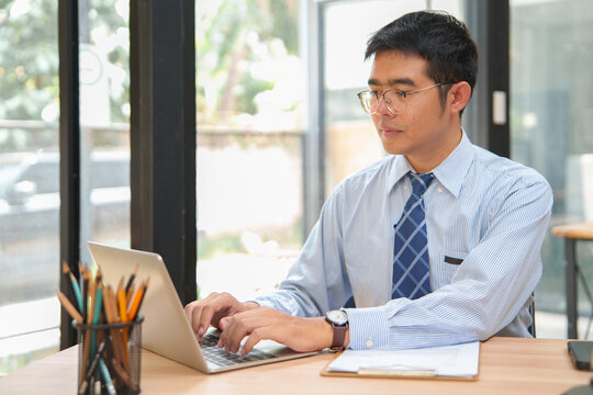 Professional man working on laptop in office, focused productivity and business concept