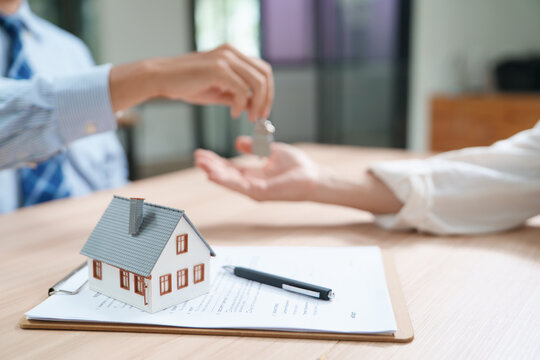 Real Estate Transaction with Home Model and Keys on Document