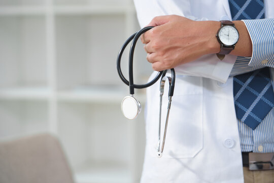 Medical professional holding stethoscope with a classic watch in healthcare setting