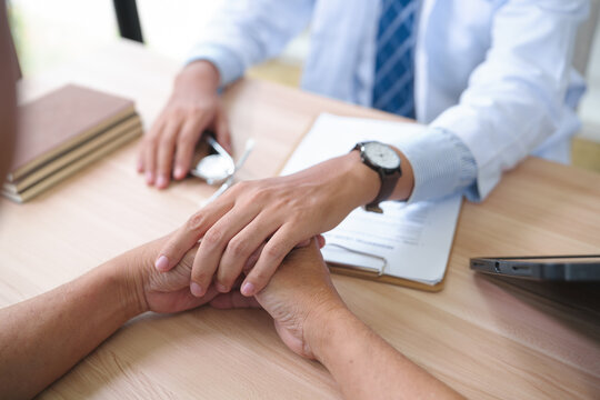 Doctor Offering Support Through Touch During Patient Consultation