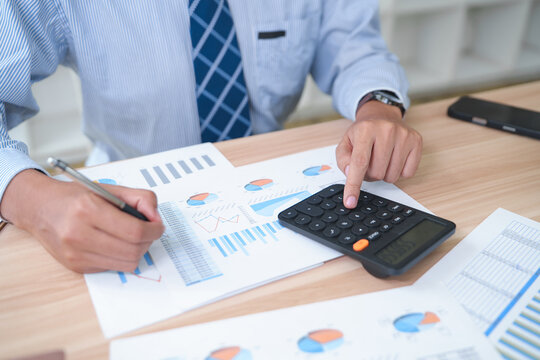 Business Accountant Analyzing Financial Reports with Calculator