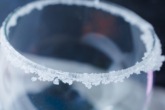 Salt crystals rimming a clear glass preparing cocktail