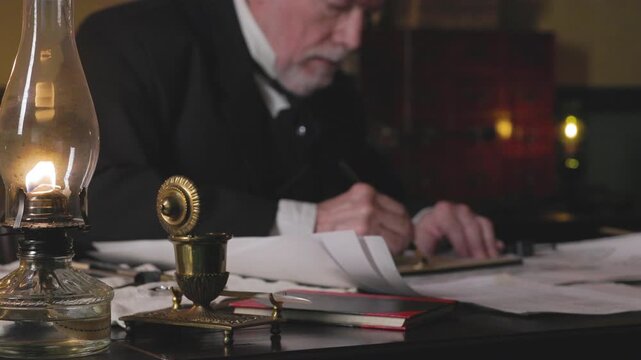 Ship architect using graphite pencil and other tools focus on oil lamp