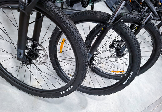 Voronezh, Russia - April 11, 2026.Close up view of bicycle front wheels featuring Kenda knobby tires and disc brakes at a sports shop in Russia