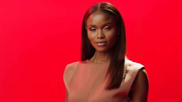 Confident model poses against red backdrop showcasing fashion and elegance