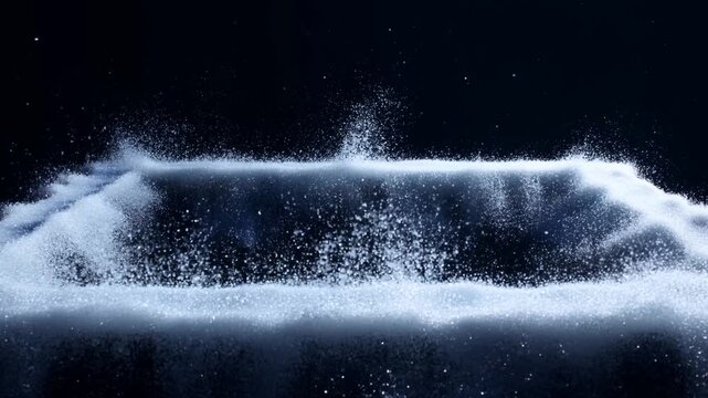 Slow motion close up of white powder particles rising and forming rectangular border on black backdrop in dark studio setting
