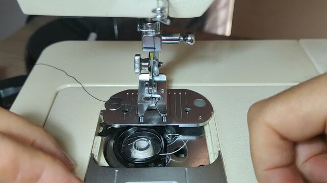Person inserting bobbin and threading sewing machine
