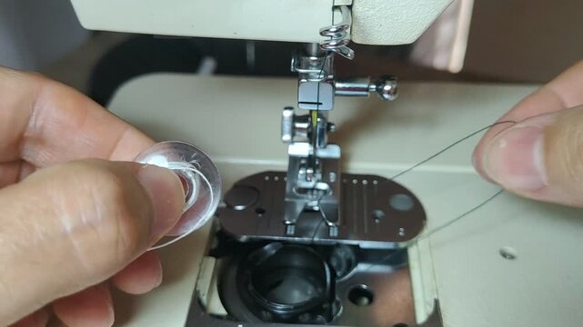 Person replacing bobbin thread in sewing machine