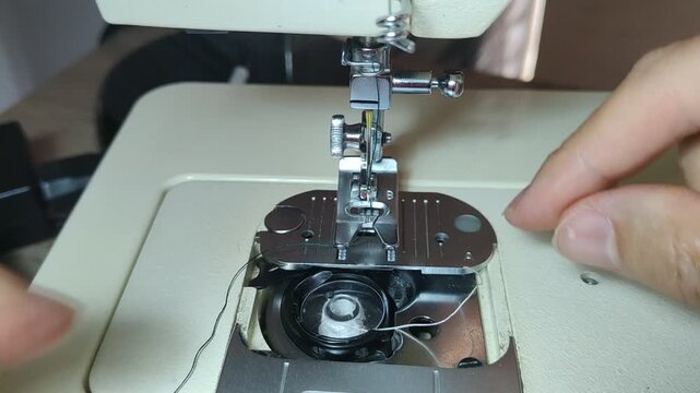Person changing the bobbin on a sewing machine