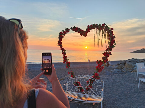Woman Photographing Heart Rose Arch Sunset Beach Scalea Calabria Italy
