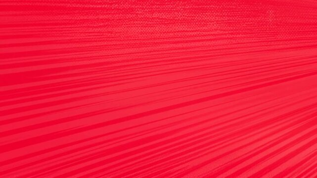 Tracking shot of red diagonal streaks sweeping across textured graphic background on seamless studio backdrop for abstract design