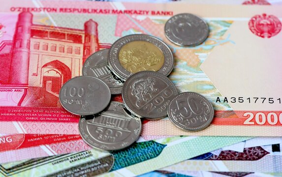 Uzbekistani som money bills and coins on table. Uzbekistan cash of UZS currency close up