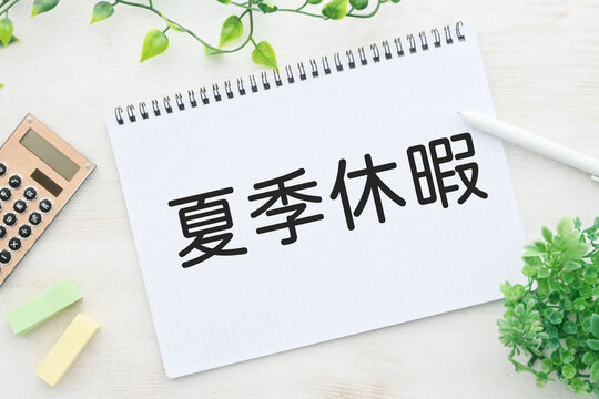 ノートに書かれた夏季休暇の文字と文房具イメージ