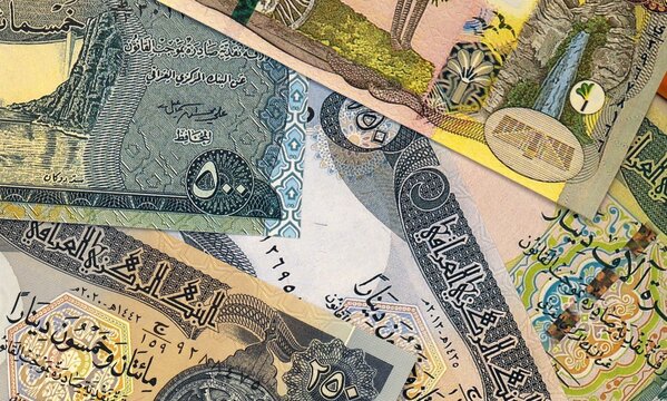 Iraqi dinar money bills in pile on table. Iraq IQD currency cash close up
