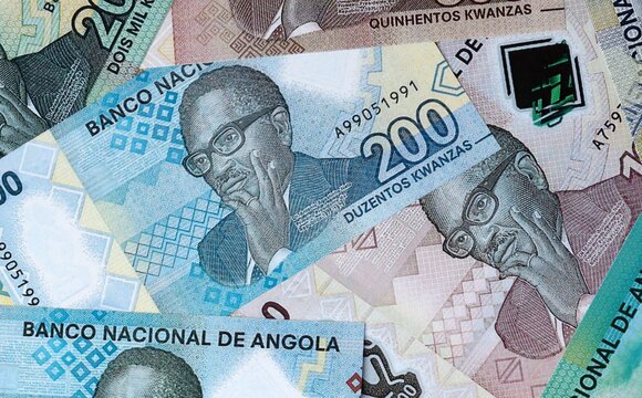 Angolan kwanza money bills in pile on table. Angola AOA currency cash close up