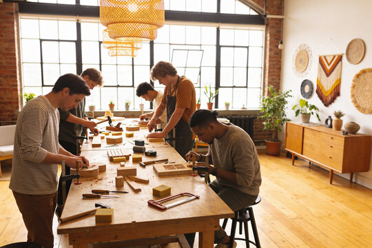Diverse group of young people participating in creative workshops and art classes. Students painting on easels, playing guitar, woodworking, and engaging in various artistic activities in bright studi