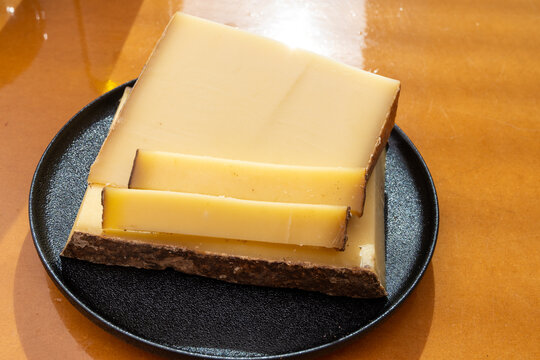 Comte hard french cheese from France's Jura Mountains made from unpasteurized cow's milk with traditional methods in cooperative dairies with nutty flavor, creamy texture, aged in natural caves