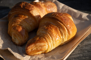 Fototapeta premium Freshly baked buttery croissants from a traditional French bakery in Brittany. Golden, flaky pastries with crispy layers, warm from the oven. Authentic French viennoiserie at its finest.