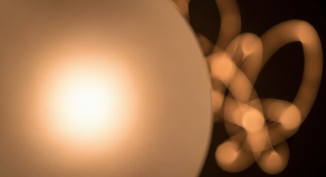 Frosted glass diffuser casting soft, warm light with bokeh effect on a dark background