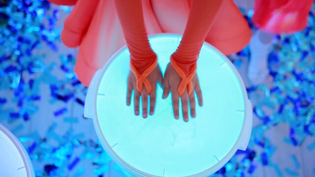 Children's hands beat on illuminated drums. Drum show. Close-up. Epic drumming performance.
