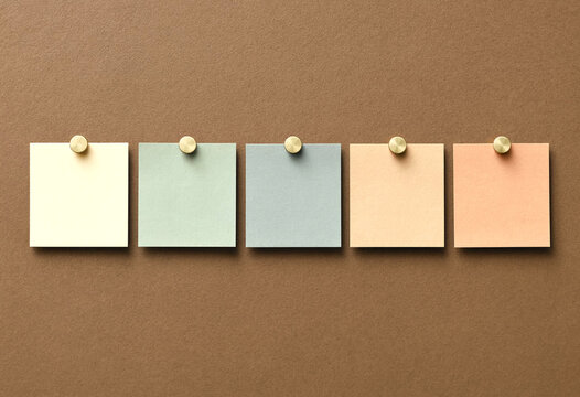 Empty pastel sticky notes pinned on corkboard minimalist flat lay composition