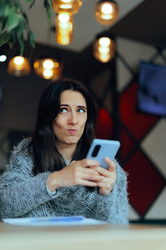 Skeptical Woman Looking Aside With Amused Expression Reading Strange Message. Disbelieving female smartphone user glances away suspiciously after receiving weird funny text notification