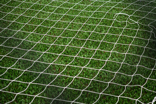 Soccer net on green grass background, soccer background image, selective focus
