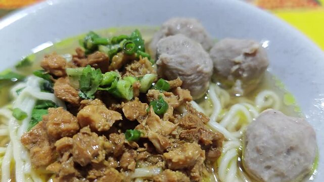 Close up of chicken noodles or mie ayam served in a bowl and still hot, steaming