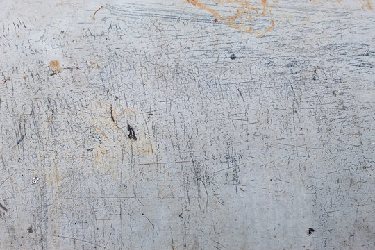 Light grey worn surface texture background with many sharp scratches, fine cracks