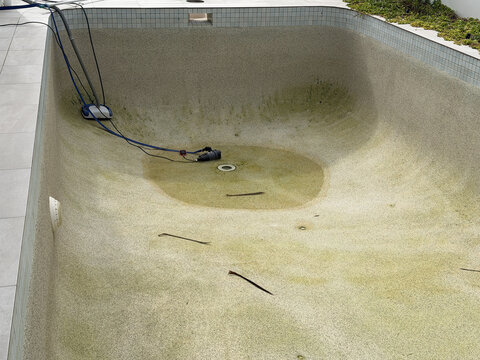 Empty Swimming Pool Undergoing Maintenance and Cleaning with Submersible Pump
