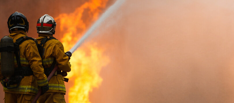 Firefighters tackling a large intense blazing fire outdoors