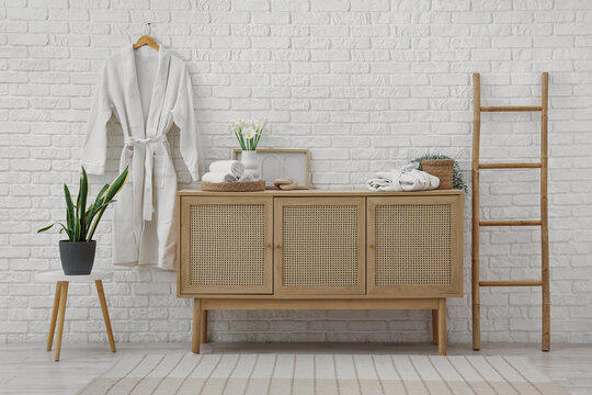 Interior of bathroom with commode, ladder and bathrobes