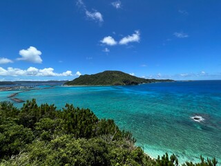 Fototapeta premium Crystal clear tropical coastline with emerald sea and green island scenery