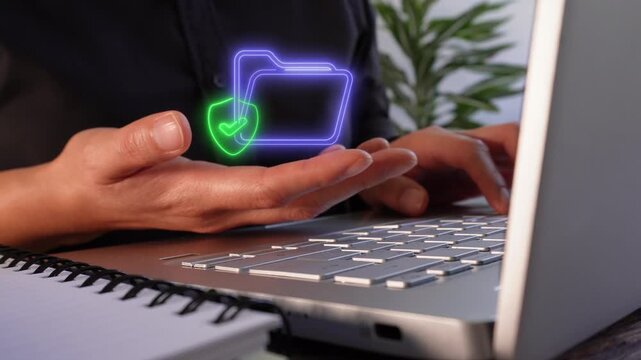 File protection. Close-up of a businesswoman's hands working on her laptop while holding a virtual folder icon and a shield with a checkmark inside.