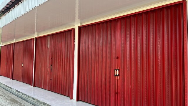 Bright red rolling shutter metal door with vertical lines as graphic resource