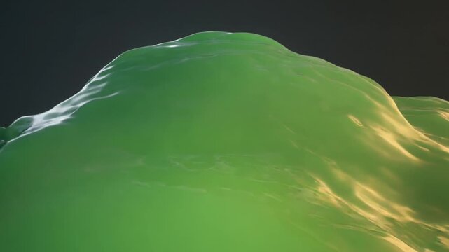Close up of rolling green viscous liquid undulating in dark light