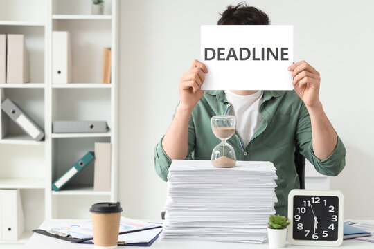 Man holding deadline sign with hourglass and stack of papers, time management and workload pressure, challenges of meeting deadlines and managing stress in a professional setting