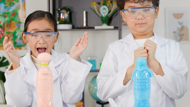 Excited Children in Lab Coats Watching Colorful Foam Erupt from Bottles