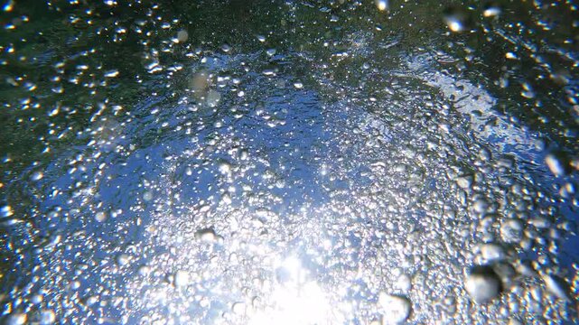 Underwater Bubbles with sunlight through water surface, natural slow motion underwater scene	
