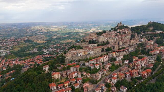 Aerial bird's eye view over cliff top buildings, San Marino City