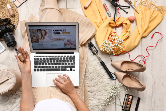 Woman using laptop for beauty blogging with makeup and accessories, online content creation and digital lifestyle