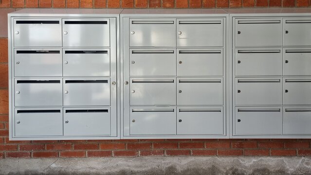 Metal postboxes for postal letters, gray mailboxes are mounted on the wall with built-in locks for protection. 