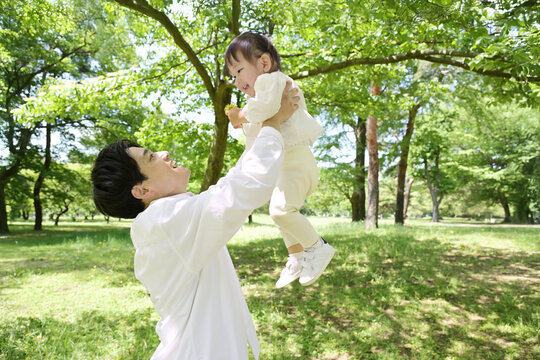 我が子を高い高いする若い父親