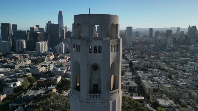 Aerial drone footage of Coit Tower in San Francisco, California, captured from above with stunning panoramic views of the city skyline, Telegraph Hill, the San Francisco Bay, and surrounding urban lan