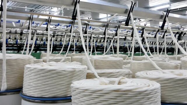 White yarn spools in textile factory production line