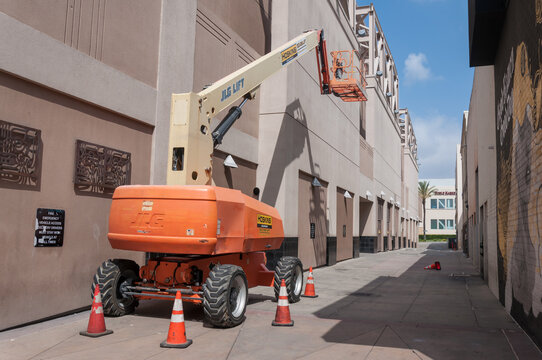 Burbank, California, USA - May 17, 2026. Hoskins Equipment - JLG Boom Lift standing on the pathway between buildings