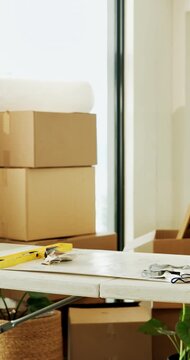 Empty room, house and boxes for renovation with table, real estate and tools for property improvement. New home, remodeling and cardboard container with equipment, refurbishment and rental apartment