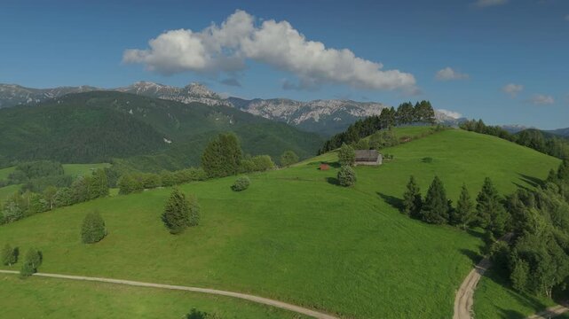 Majestic Bucegi Mountains over pastoral Transylvania with a dramatic ascending reveal of deep forest valleys in Simon Bran, cinematic sweeping drone shot